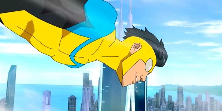 Mark Grayson as Invincible flies through the air. Behind him is a city skyline. He is wearing his iconic yellow and blue costume.