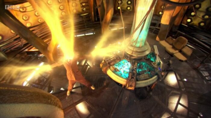 The Tenth Doctor regenerates inside the TARDIS, golden energy radiating out of his head and arms