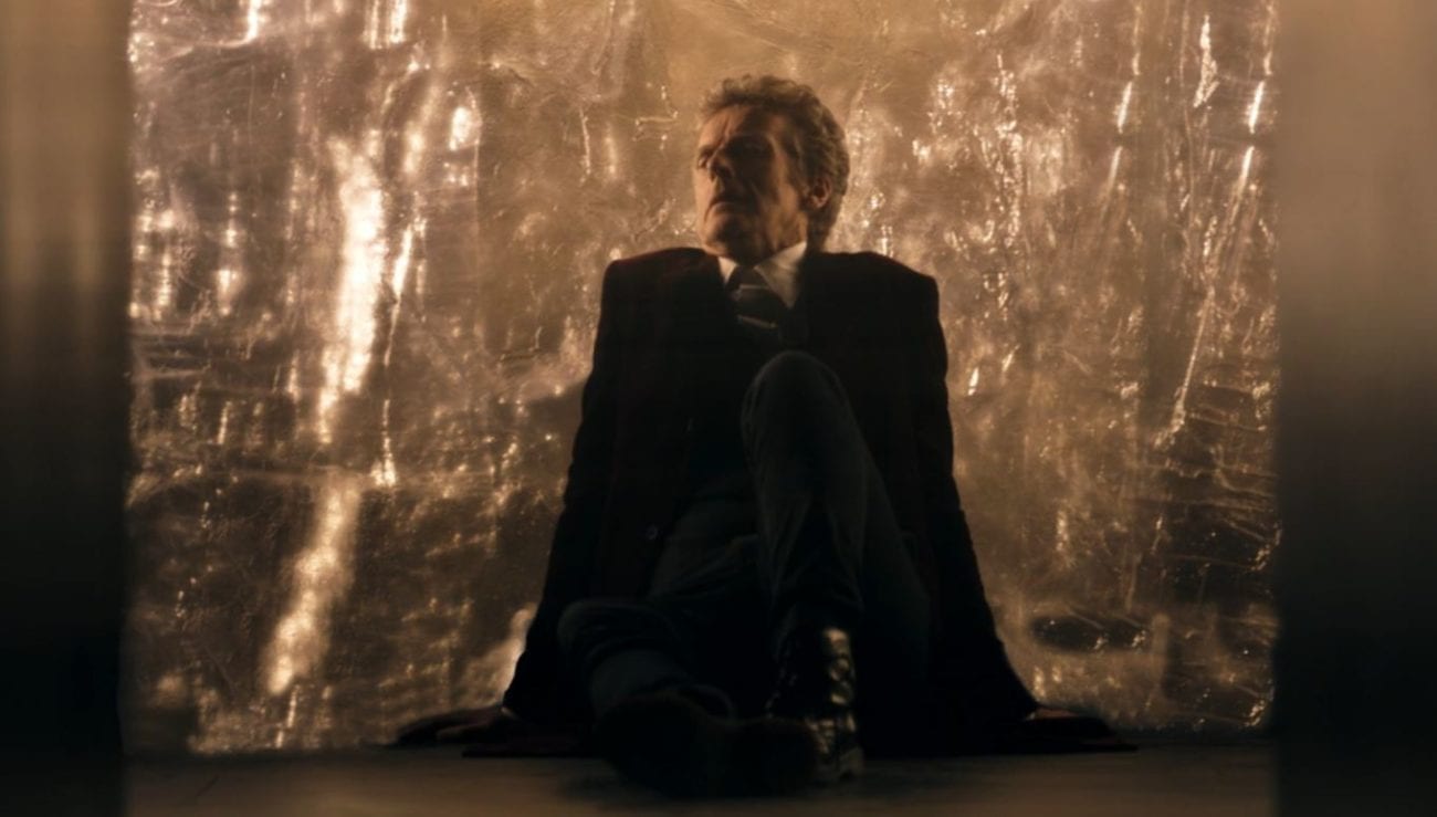 The Doctor sits on the floor by the spantium wall in Doctor Who Heaven Sent