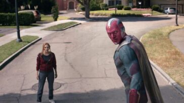 Vision looks over his shoulder as Wanda looks on, standing in the street, in WandaVision 'The Series Finale'
