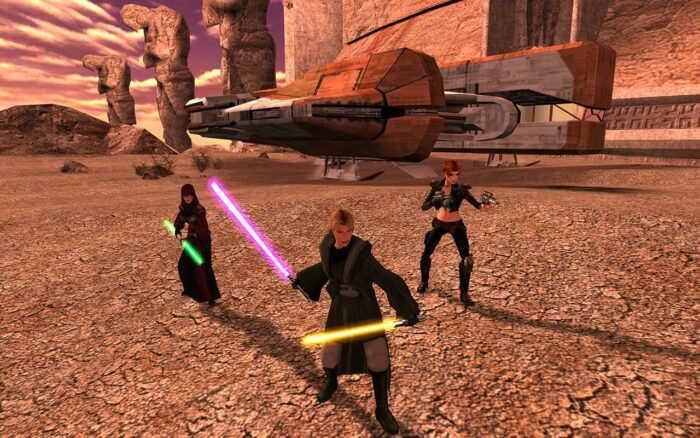 KOTOR 2 screenshot featuring the party; a jedi in grey robes with two lightsabers, another jedi with a double blade green saber, and a gunslinger with two pistols