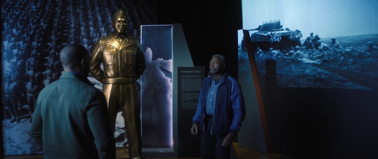 Sam Wilson shows Isaiah Bradley and his grandson a tribute exhibit in The Falcon and the Winter Soldier