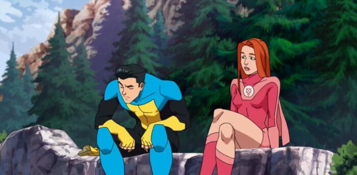 Atom Eve and Invincible sit on a ledge over a waterfall.