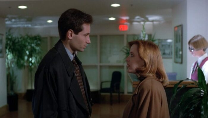 A two-shot of Mulder and Scully looking at each other in 'Excelsis Dei' (S2E11)