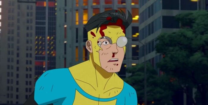 Invincible is stunned after being punched by Omni-man into downtown Chicago. His face and nose are bloody, and one of the lenses on his costume has shattered.