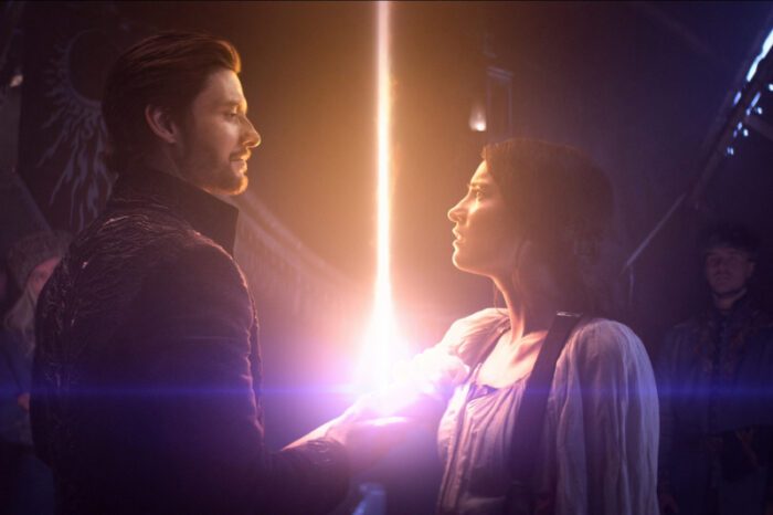 General Krigan (Ben Barnes) looking into Alina's (Jessica Mei Li) eyes as a giant spark of light emanates from her wrist