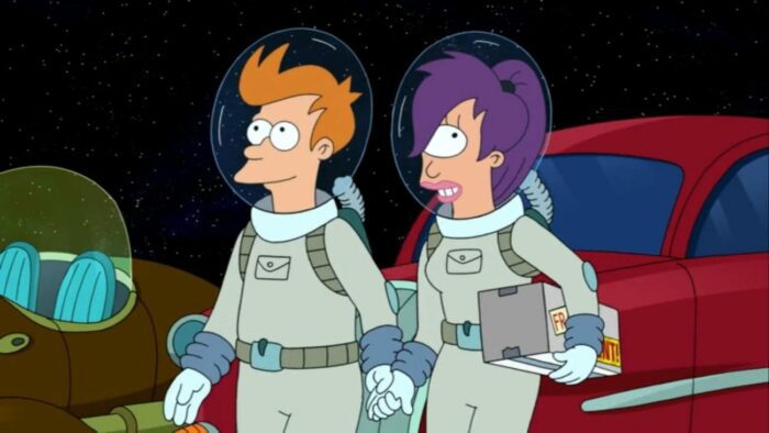 Fry and Leela hold hands while wearing spacesuits in the parking lot of Luna Park. Leela holds the delivery 