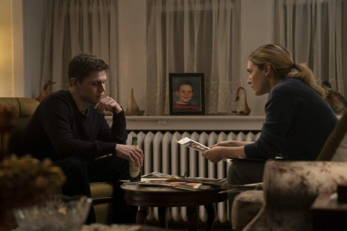 Mare (Kate Winslet) and Detective Zabel (Evan Peters) look over evidence