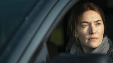 Mare (Kate Winslet) sits in her car.