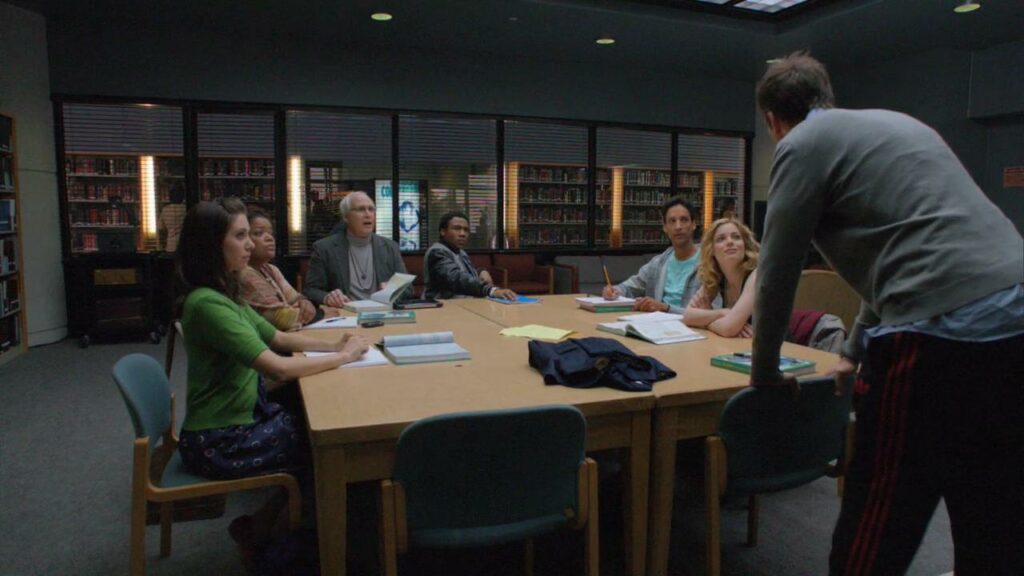 Annie, Shirley, Pierce, Troy, Abed, and Britta sit at the study room table watching Jeff give a speech