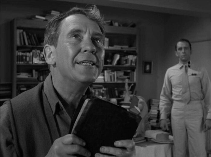 Still from The Twilight Zone episode "Time Enough at Last." he Obsolete Man. Romney Wordsworth looks to heaven while holding his bible. The Chancellor looks on.