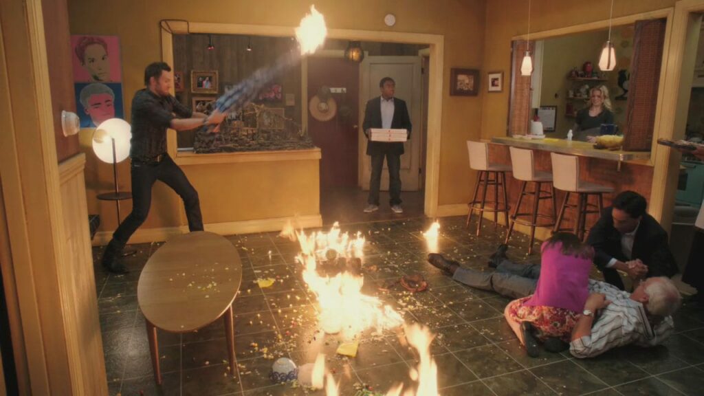 Troy and Abed's apartment is on fire, Jeff is swinging a burning sheet, Troy is holding pizzas and looking stunned, Annie and Abed comfort an injured Pierce