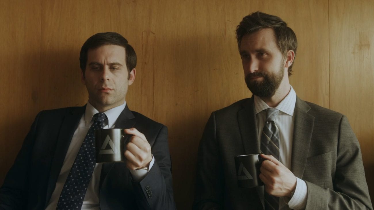 Two men hold coffee mugs and make faces in Comedy Central's Corporate