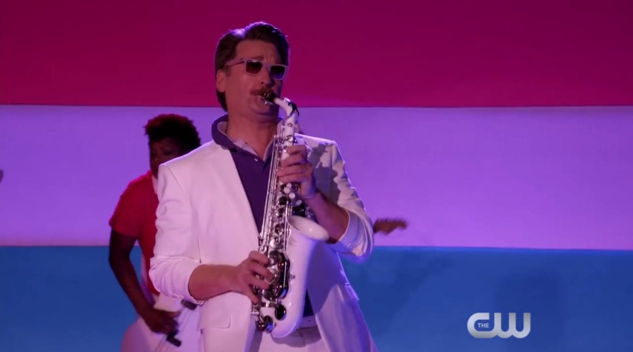Darryl plays the trumpet in front of a bisexual flag 