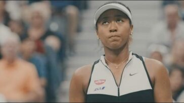 Naomi Osaka looks upwards as she wears a visor during a tennis match