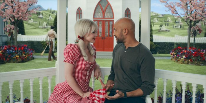 Betsy (Dove Cameron) and Josh (Keegan-Michael Key) sitting in the gazebo in front of the church looking at each other