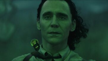 Loki looks at his first successful enchantment, bathed in green light.