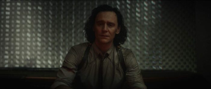 Loki sits on the steps of a TVA office and cries.