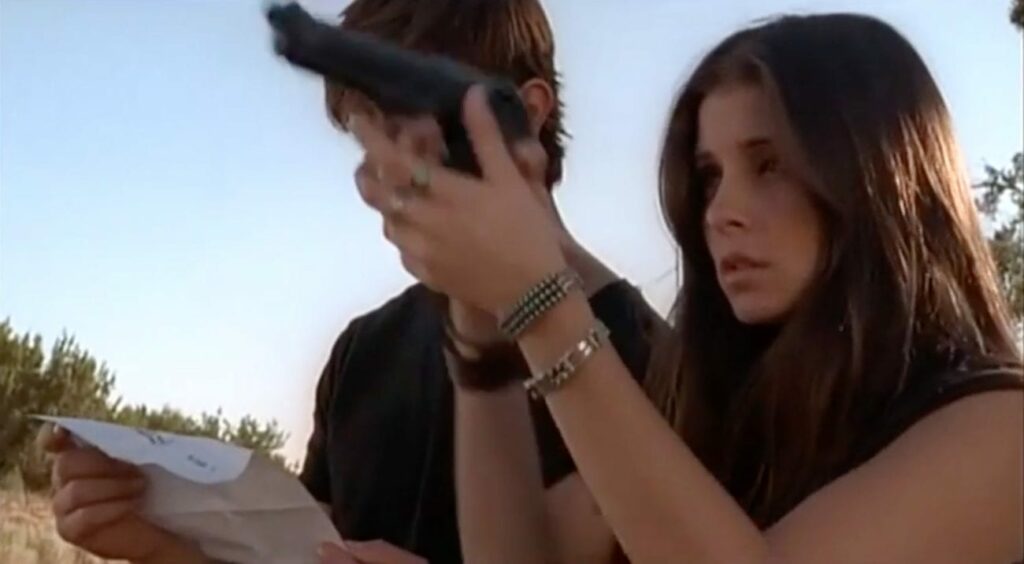 Liz Parker holding gun with Max looking down next to her