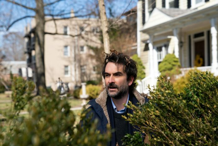 Bill (Jay Duplass) standing in shrubbery with a quizzical look on his face