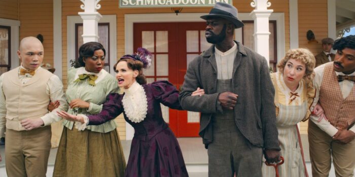 Mrs. Layton (Kristin Chenoweth) singing to the locals who begin to give looks of agreement and link arms in front of the Schmigadoon Inn