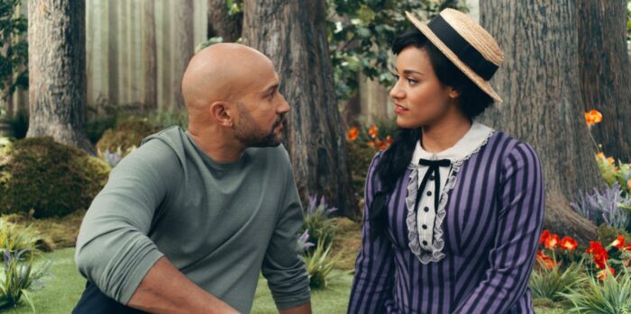 Josh (Keegan-Michael Key) and Emma (Ariana DeBose) sitting in the woods looking at each other with sad and serious expressions