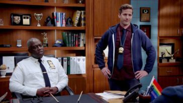 Holt sits behind his desk while Jake stands at his side