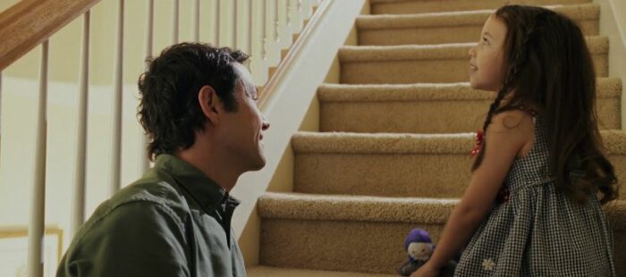 Josh talks to Sara as she sits on the steps