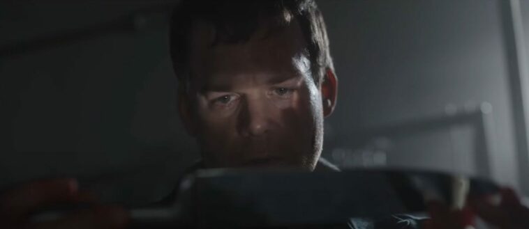 Dexter sees his reflection in a butcher knife the light of which shows over his eyes.