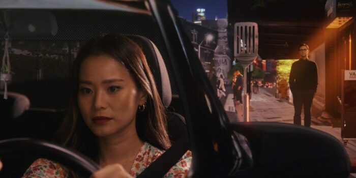 Emily drives a car away from Josh, who stands in the background near a giant animated spatula in a sequence from the season finale of Mr. Corman "The Big Picture"