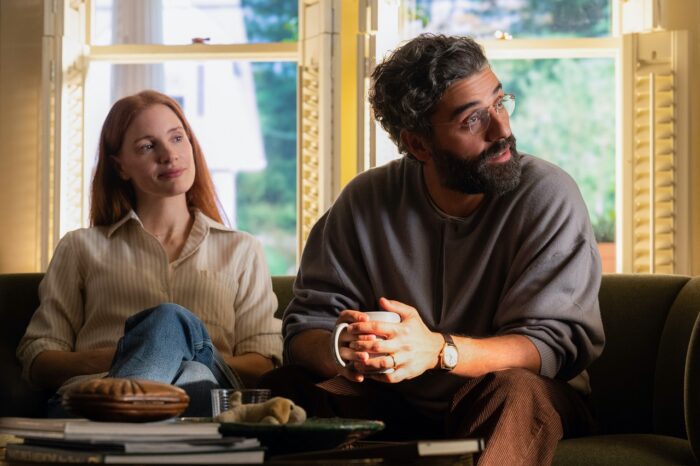 In this image from Scenes from a Marriage, the characters Mira (Jessica Chastain) and Jonathan (Oscar Isaac) are depicted seated in a living room, both looking at an unseen interviewer to their left.