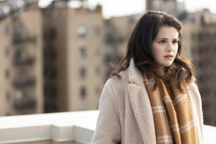 Mable (Selena Gomez) stands on a roof, wearing a scarf and overcoat, looking distraught