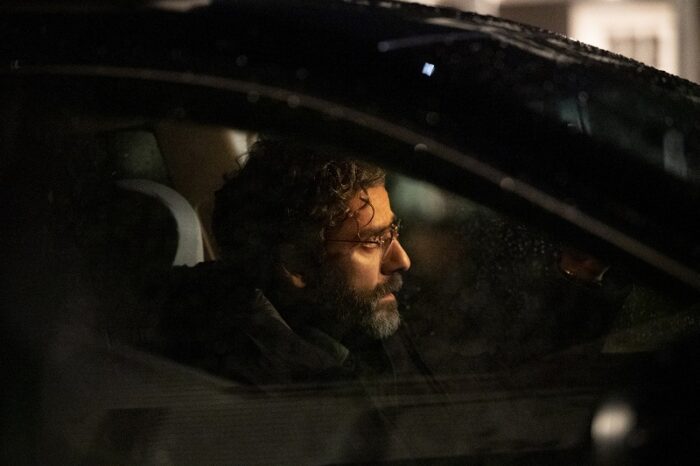 Jonathan (Oscar Isaac) is depicted behind the wheel of his car, looking back into his rear-view mirror as he slowly drives away.