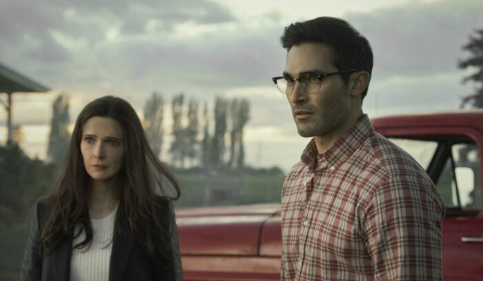 Lois and Clark stand behind their old pickup truck in front of their sons.