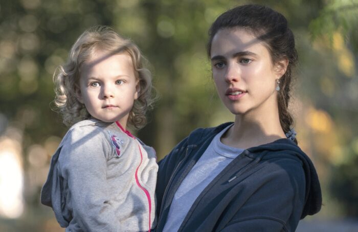 Maddy (Rylea Nevaeh Whittet) and mother Alex (Margaret Qualley) are depicted in partial sunlight looking slightly right of camera in this image from Netxlix's limited series Maid.