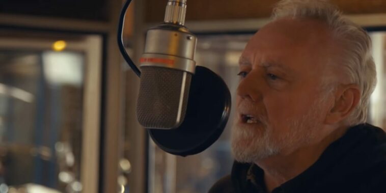 Roger Taylor sings in a recording studio in the music video for "We're All Just Trying to Get By"