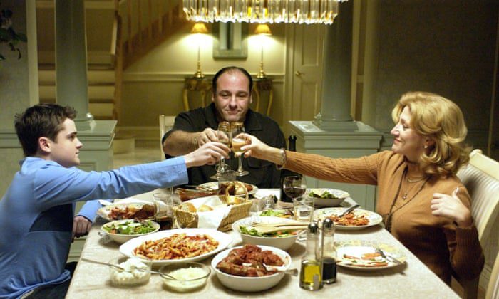 Tony, A.J., and Carmela Soprano clinking glasses during family dinner.