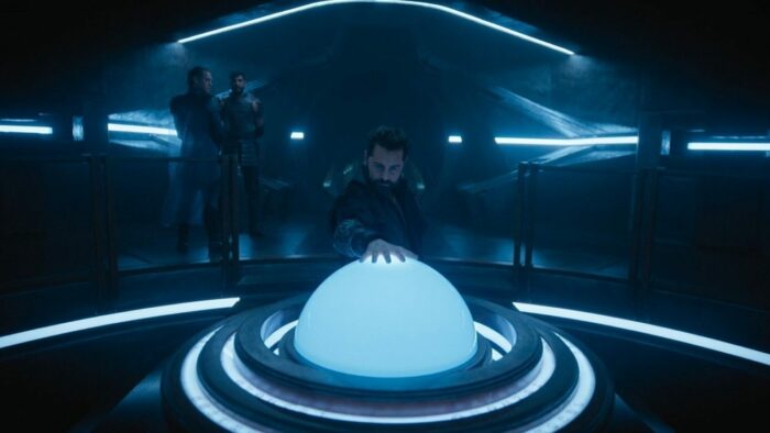 Foundation S1E10 - Hugo places his hand on the giant glowing trackball control of the Invictus' bridge