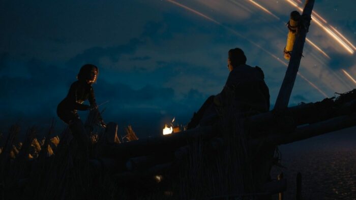 Foundation S1E10 - Gaal and Salvor stand on a tilting platform at dusk, with the rings of Synnax in the background