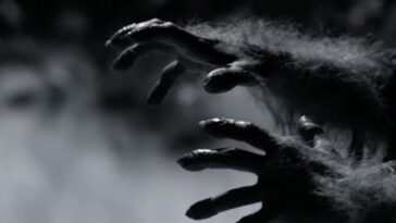 Werewolf hands creeping across the screen in black and white