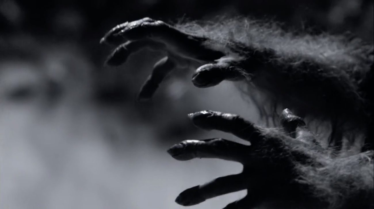 Werewolf hands creeping across the screen in black and white
