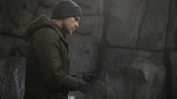 Dexter wears a beanie as he looks around a cave