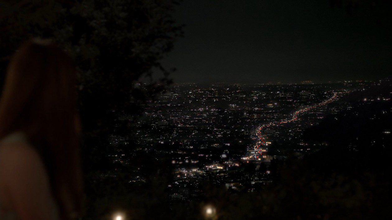 Emma looks out over Los Angeles at night