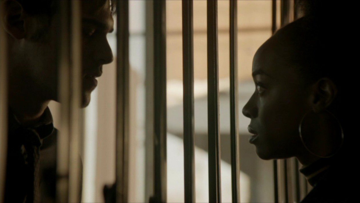 Brian and Kristin look at each other through the bars at the Black Panther Party headquarters