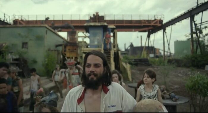 The Prophet (Daniel Zovatto) leads a group of children away from a blue staircase where Kirsten (Mackenzie Davis) looks on