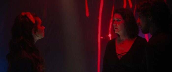 Callie looks indignant as Shauna confronts her at a club, which is bathed in red light