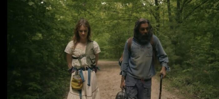 Kirstin and Jeevan walking along the path to the crossroads in the woods