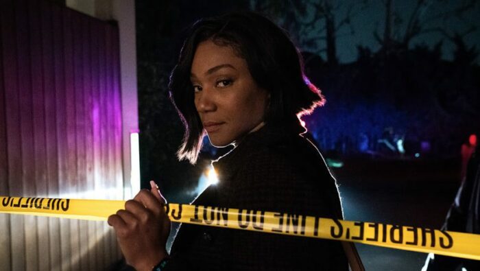 Detective Danner (Tiffany Haddish) looks over a yellow crime scene tape