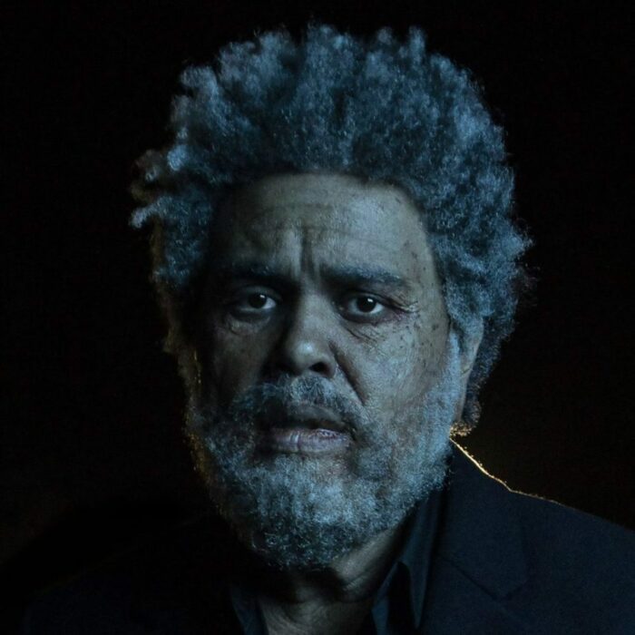 The Weeknd - Dawn FM album cover, an aged Abel Tesfaye looks into the light surrounded by darkness