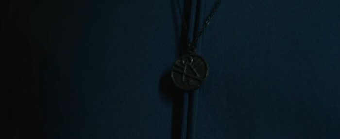 The symbol as a pendant in front of a purple shirt